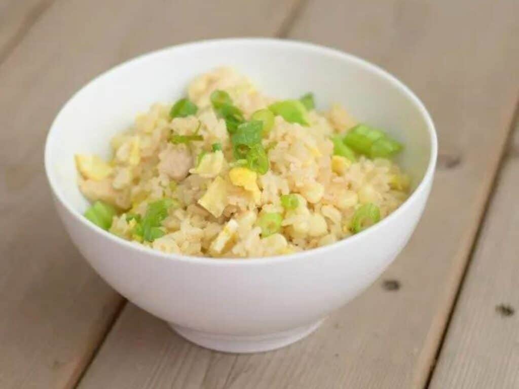 Image shows delicious chicken fried rice in a bowl.