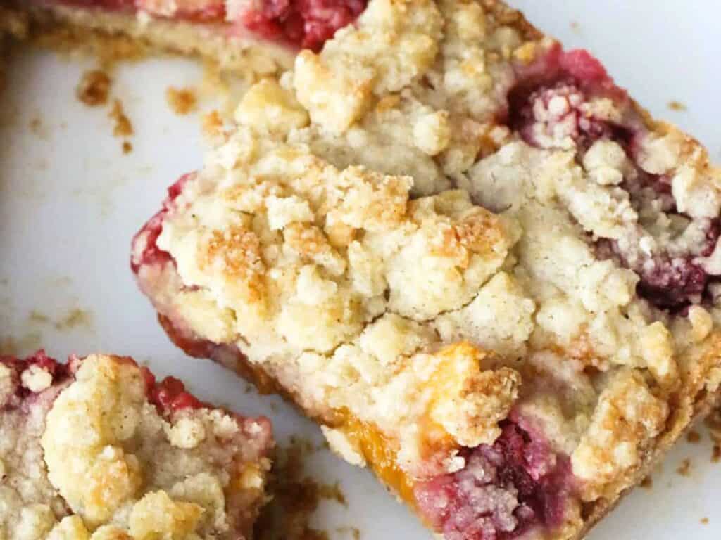 Image shows delicious peach raspberry bars.