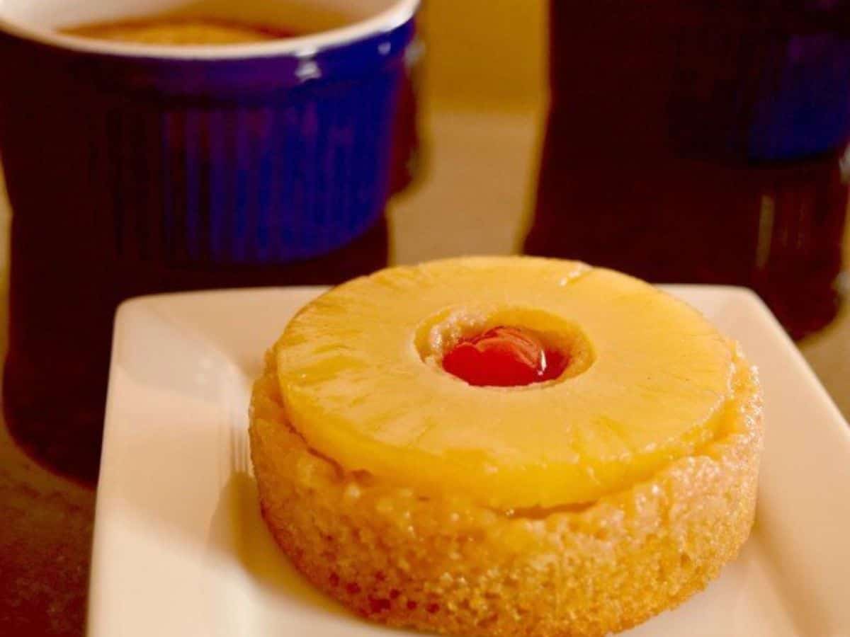 Individual pineapple upside down cake on a small white plate.
