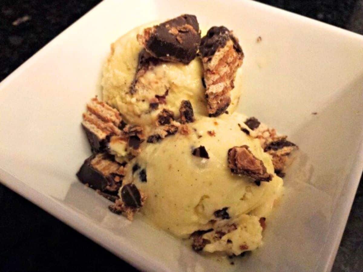 Bowl of salted caramel ice cream with chopped candy on it.