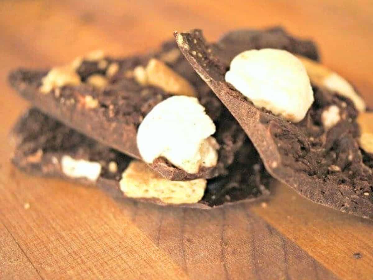 Image shows a Stack of smores bark on a wooden table.