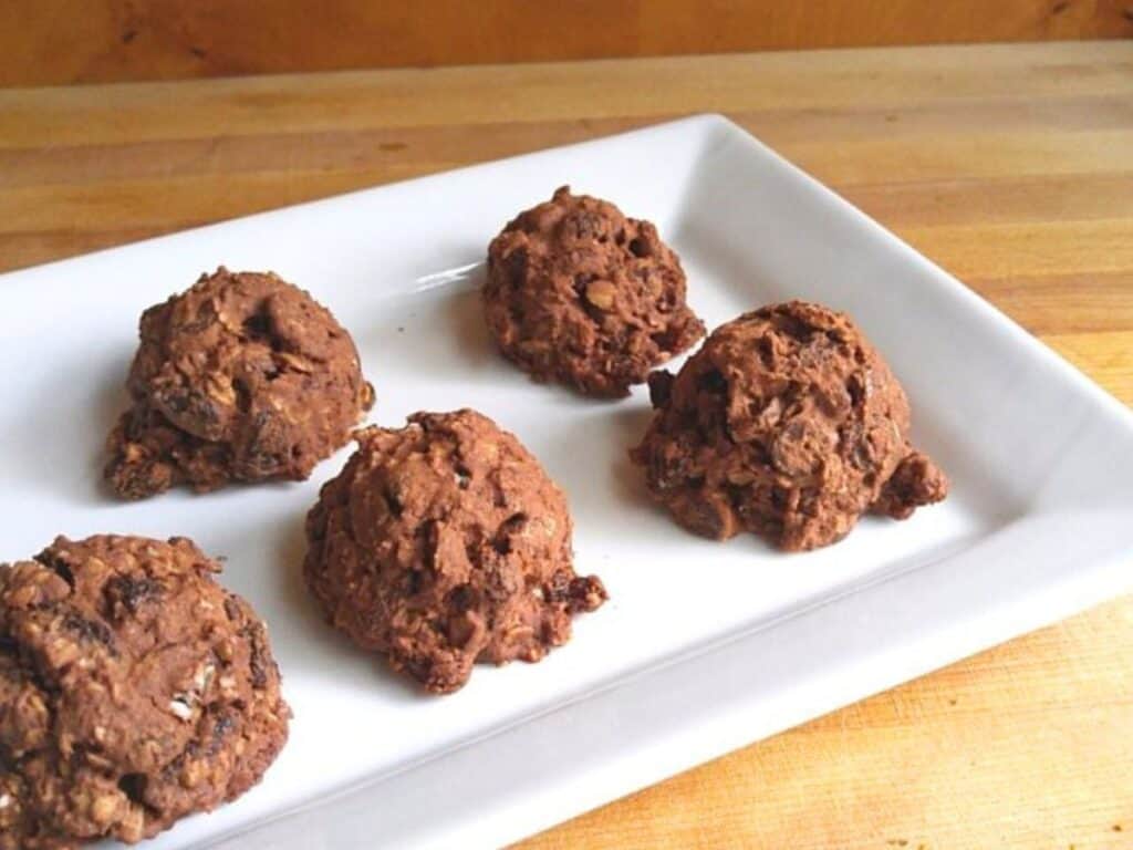 Image shows easy to make chocolate raisin cookies on a plate.