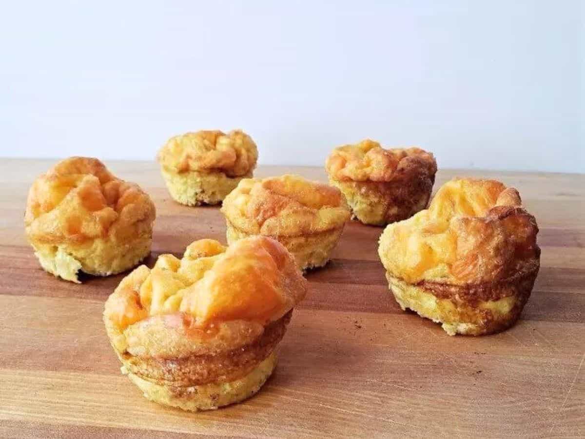 Image shows five Egg Muffin Cups sitting on a wooden board.