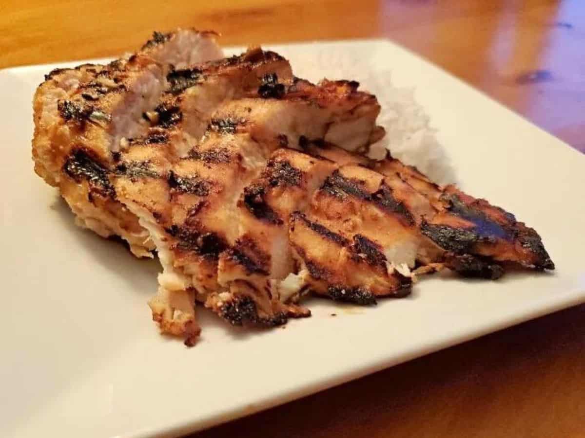 Miso glazed chicken with rice on a white plate.