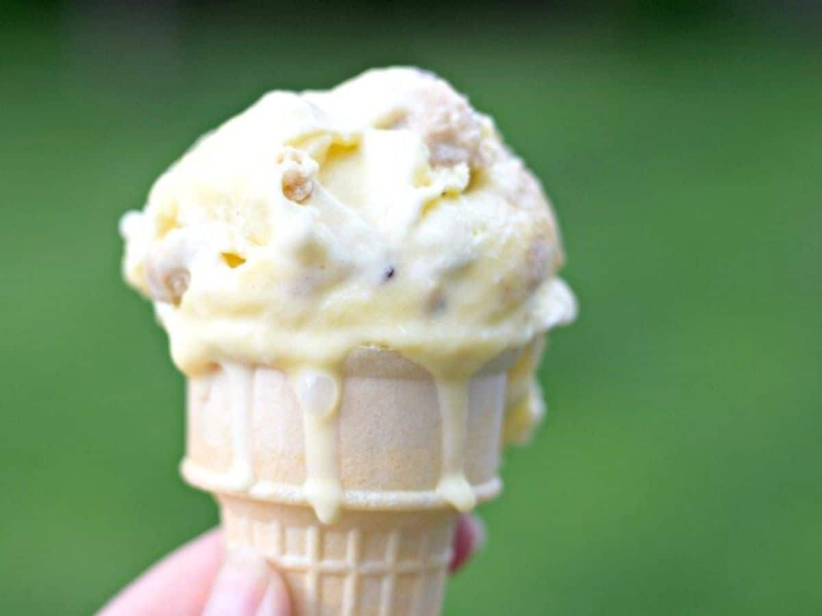 Cookie dough frozen custard on a cone with drips.