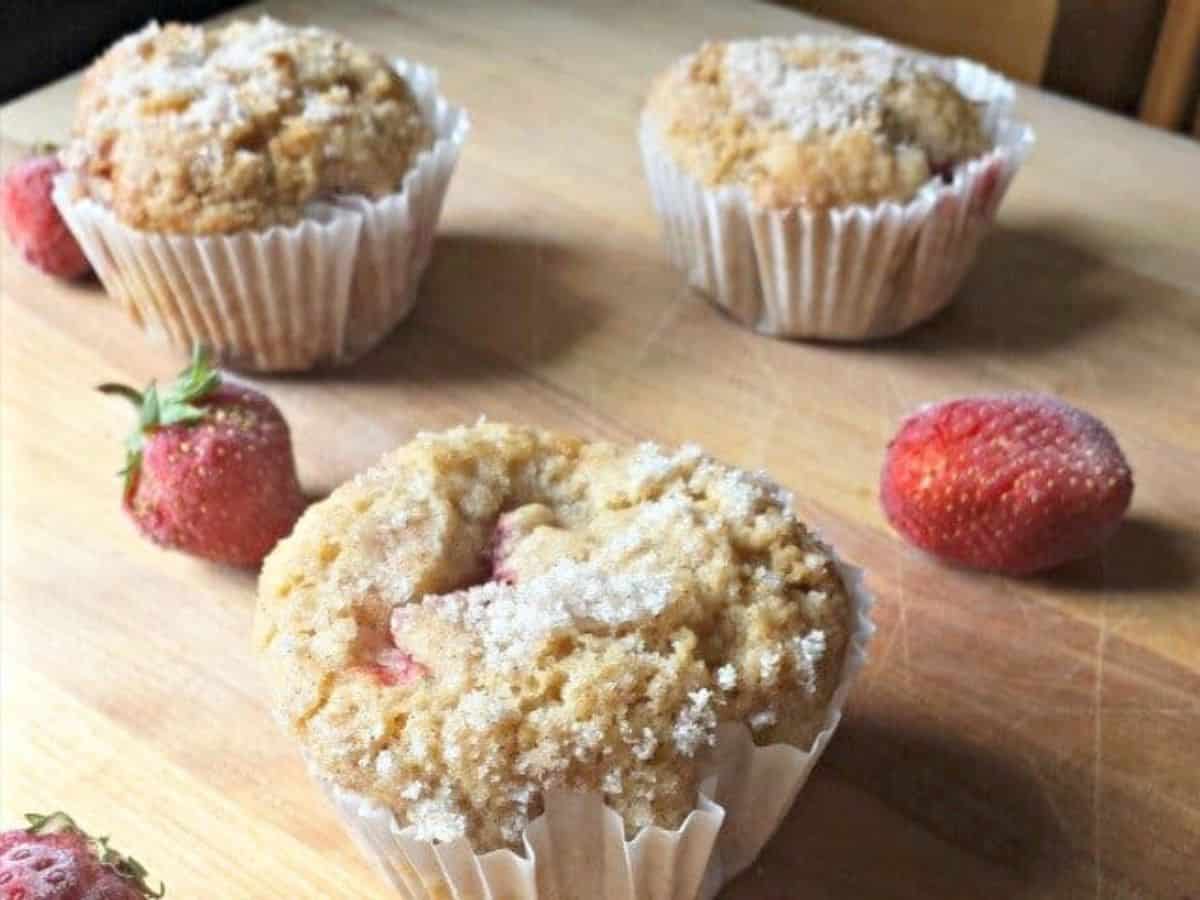 Two pans of strawberry muffins sitting on a black stovetop.