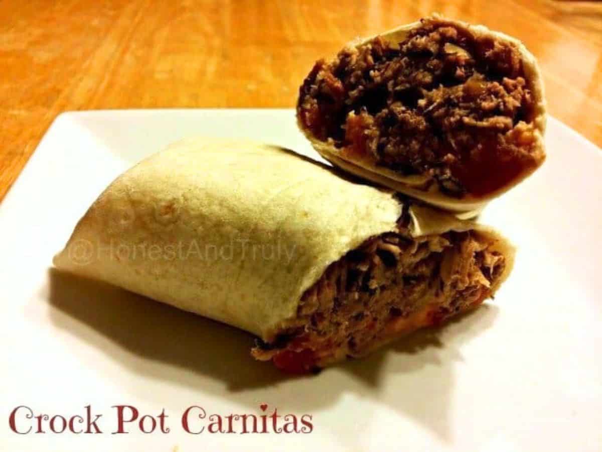 Image shows Tongs holding carnitas over a tray.