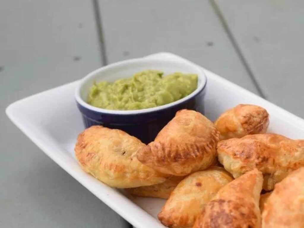 Image shows plate full of puff pastry beef empanadas.