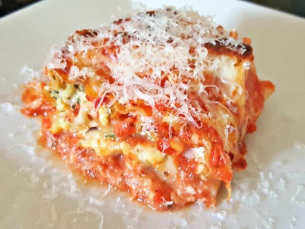 Image shows plated and ready to eat lasagna roll up.