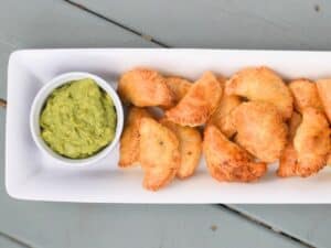 Image shows serve and ready to eat puff pastry beef empanadas.