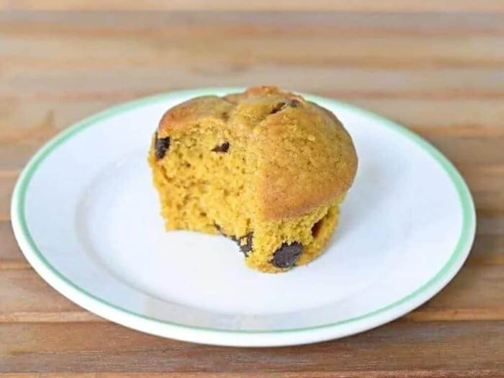 Image shows simple and delicious chocolate chip pumpkin muffin on a plate.