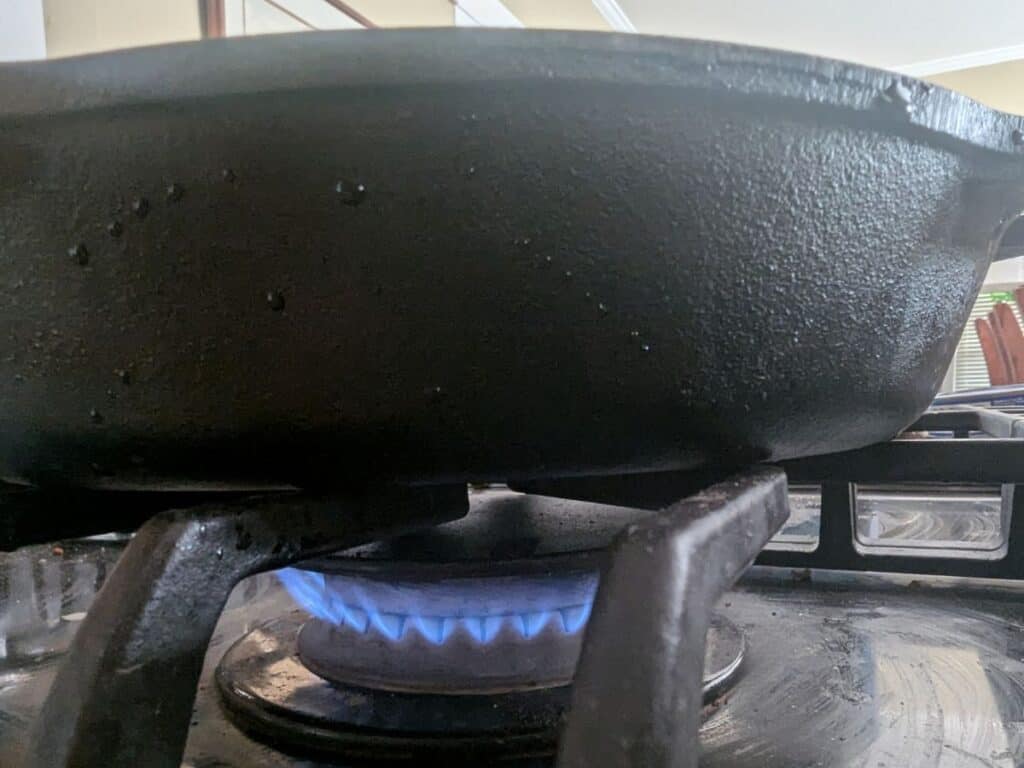 Image shows a Cast iron pan being heated on a stove.