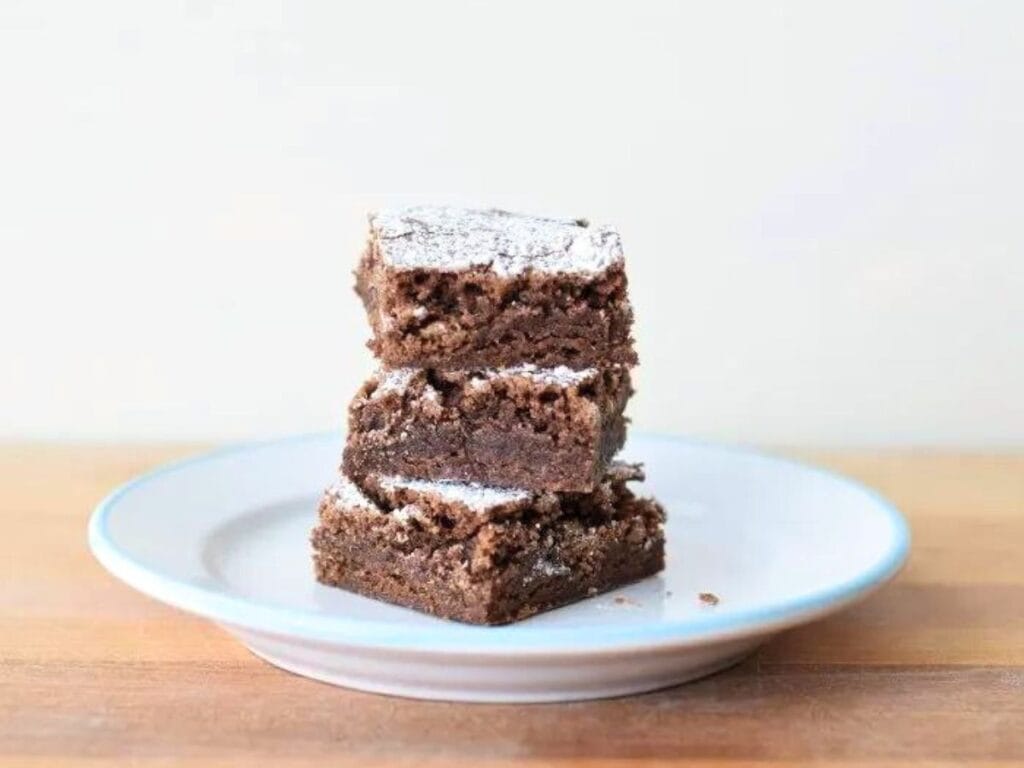 Image shows delicious classic brownies on a plate.