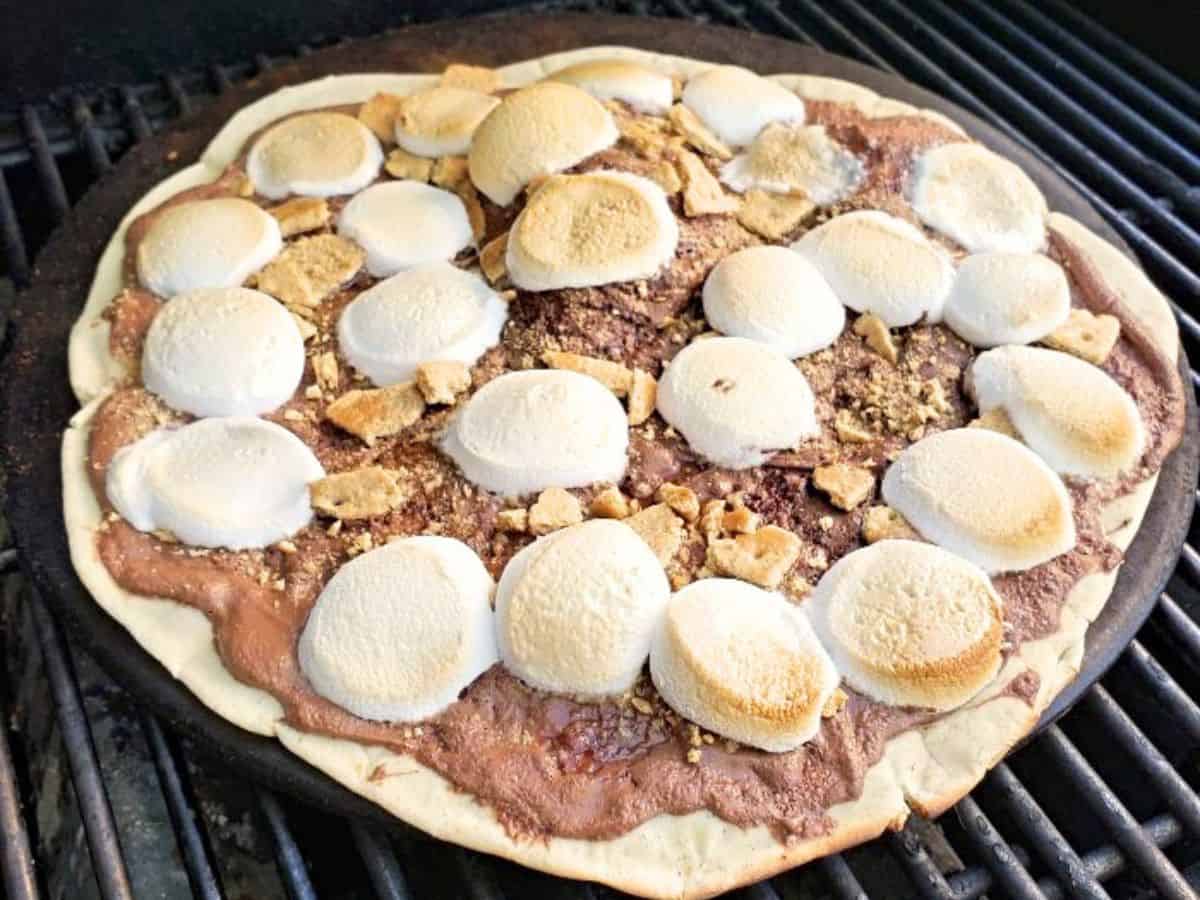 Image shows a grilled s'mores pizza on the grill.