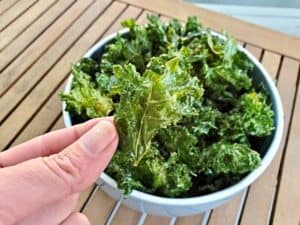 Image shows delicious homemade baked kale chip.