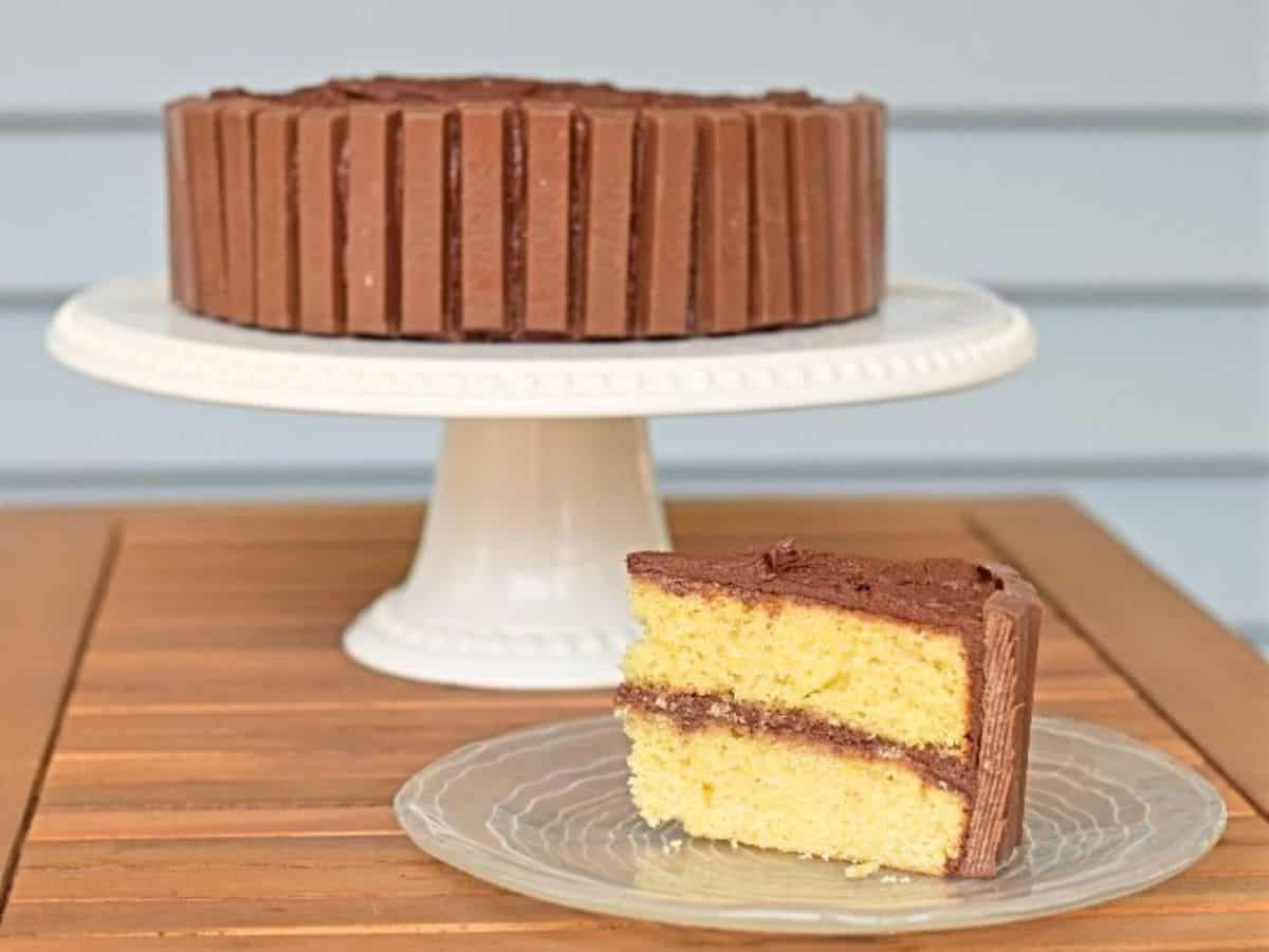 Image shows a Kit Kat cake on a white cake stand with a white background.