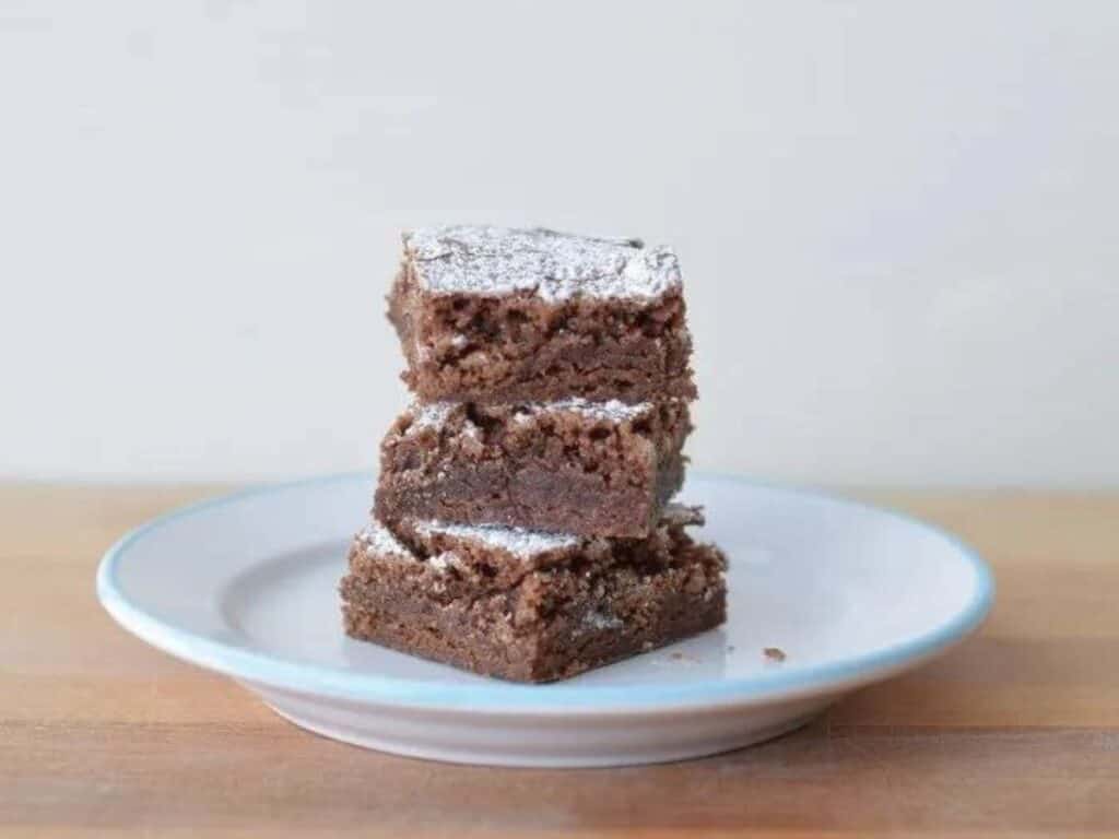 Image shows easy to make classic brownies on a plate.