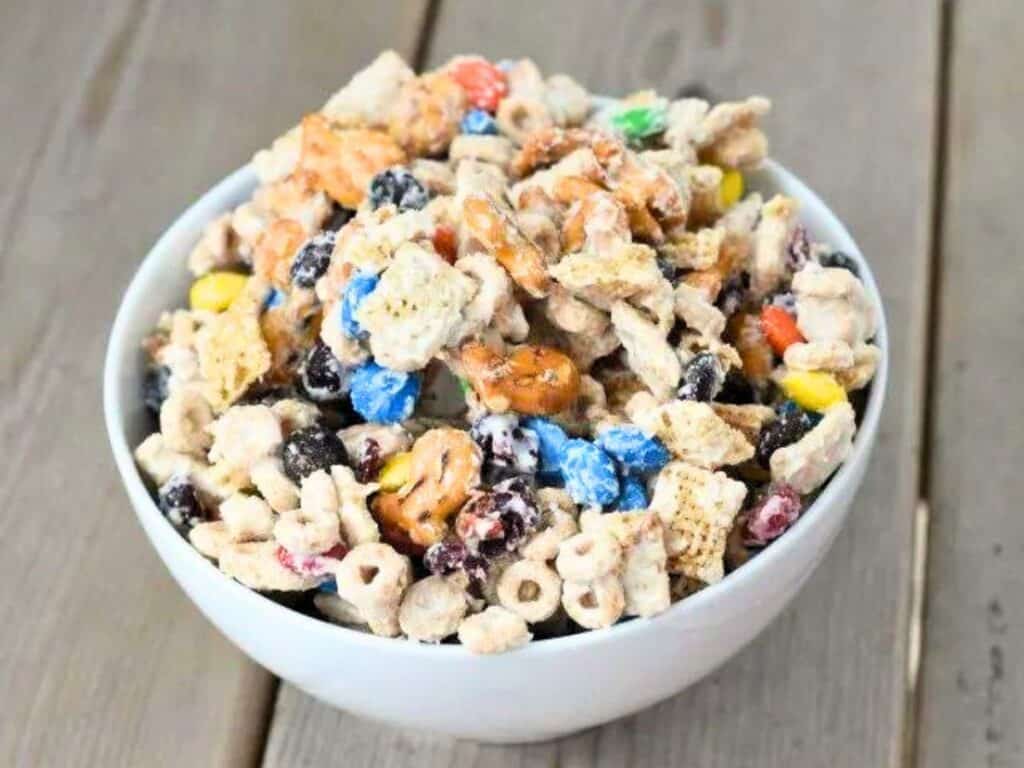 Image shows white chocolate party mix in a bowl.