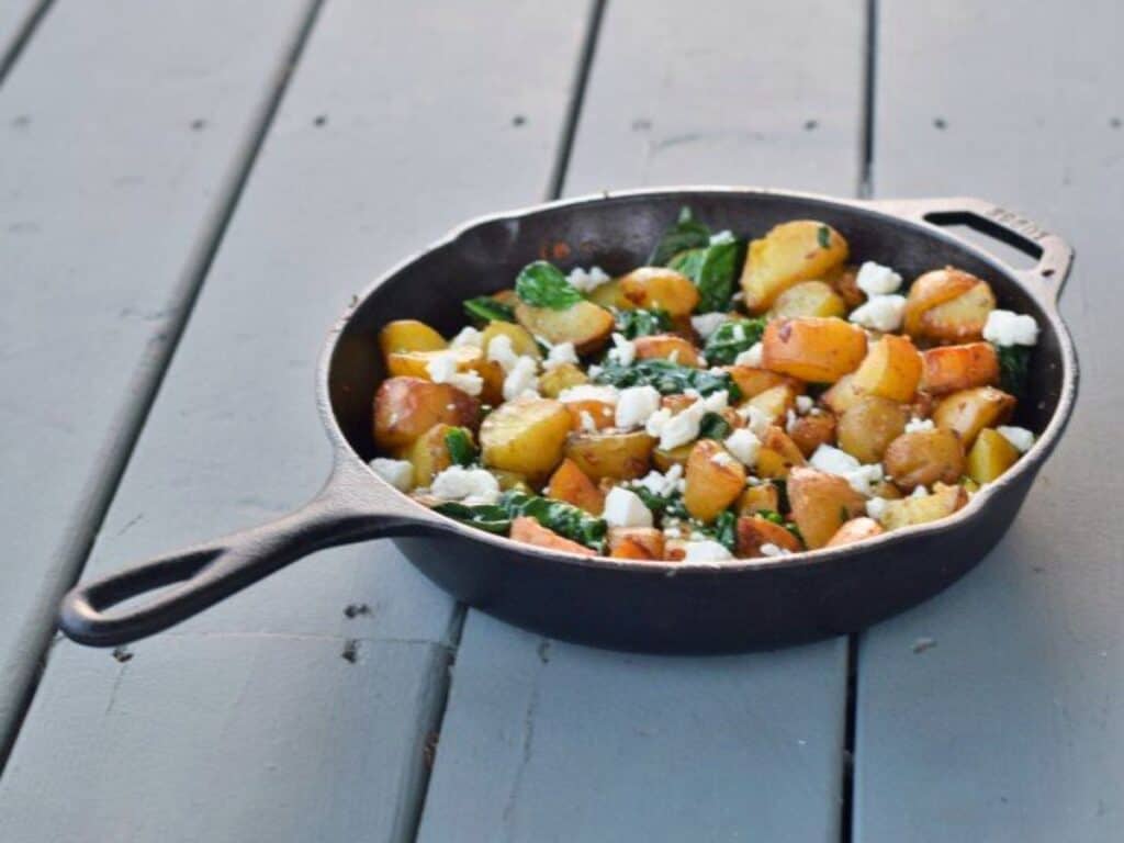 Image shows yummy oven roasted potatoes with spinach and garlic.