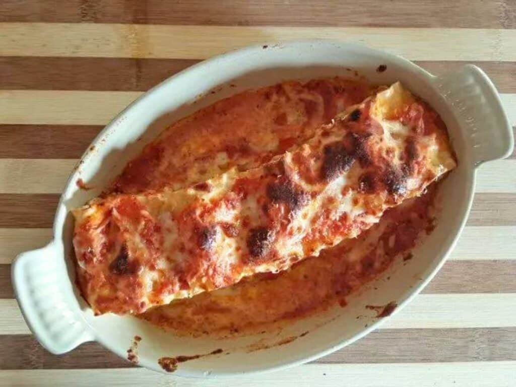 Image shows baked lasagna roll up recipe.