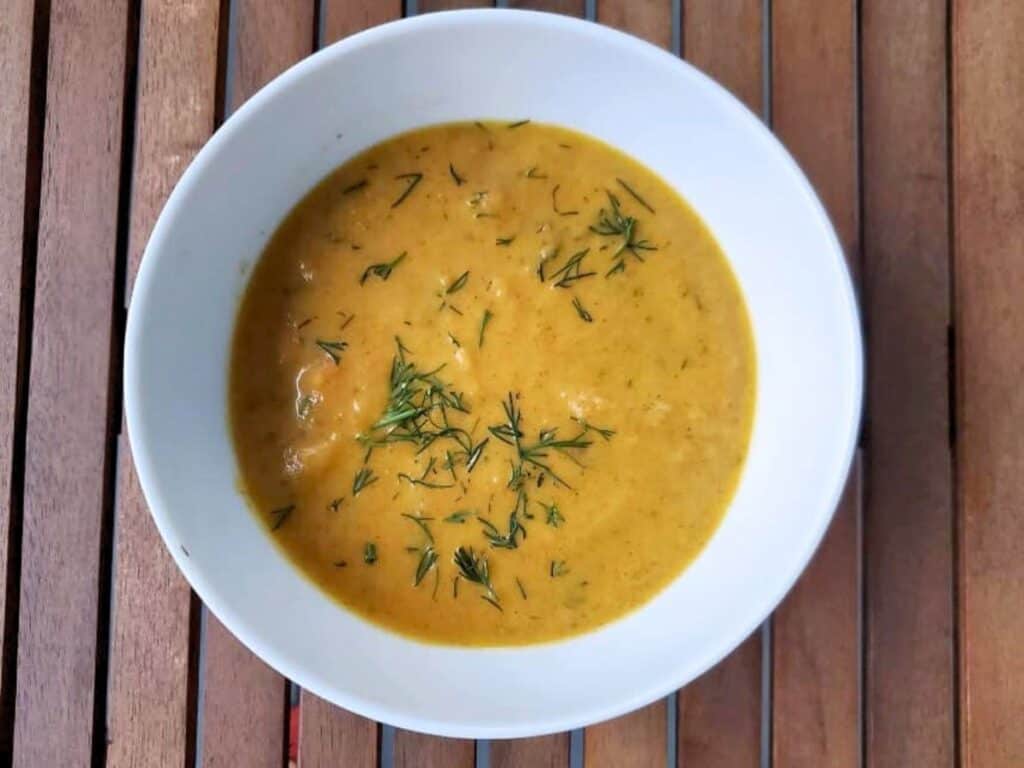 Image shows bowl of irresistible carrot ginger soup.