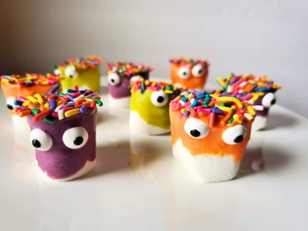 Image shows Cute monster marshmallows on a white platter.