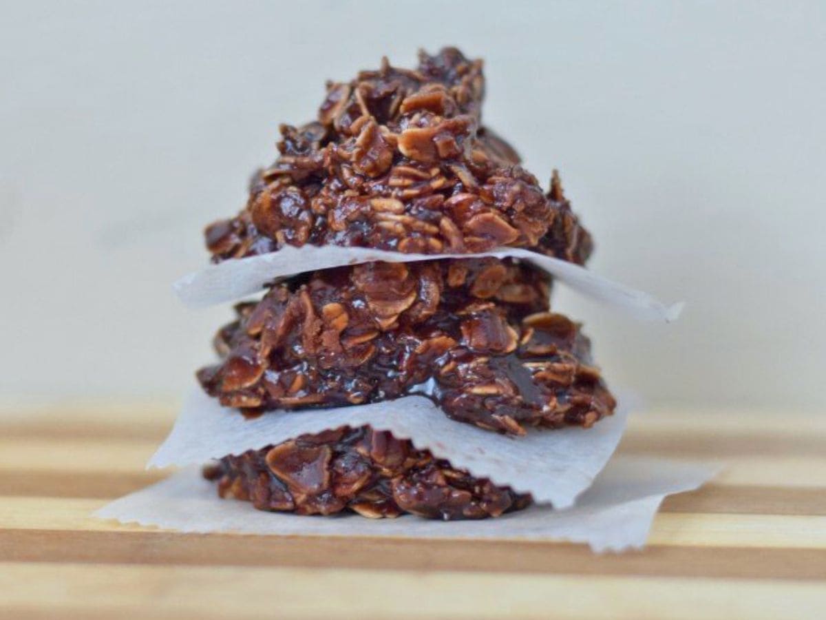 Image shows no bake nutella cookies on wax paper sitting on a wooden board.