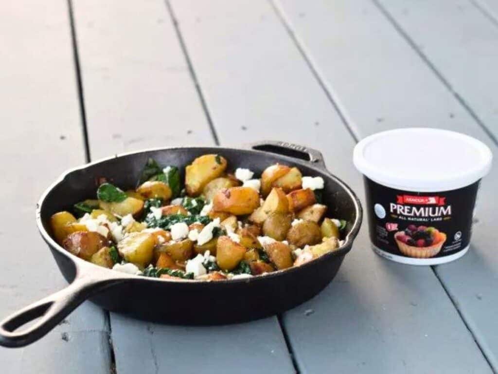 Image shows irresistible oven roasted potatoes with spinach and garlic.
