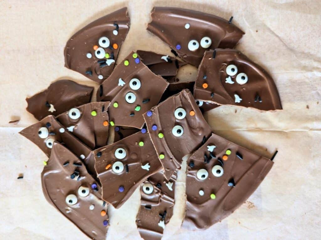 Image shows an Overhead of Halloween chocolate bark on parchment paper.