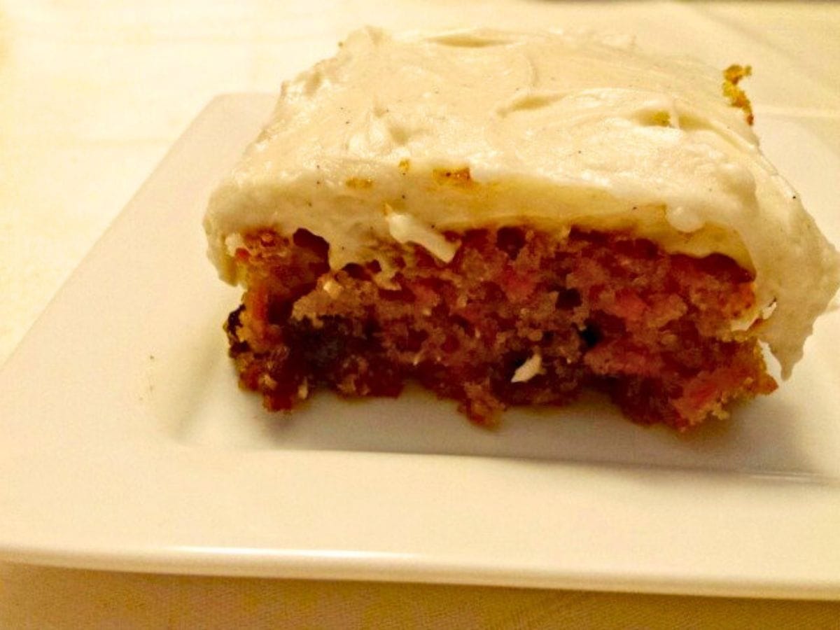 Image shows a piece of carrot cake on a white plate.
