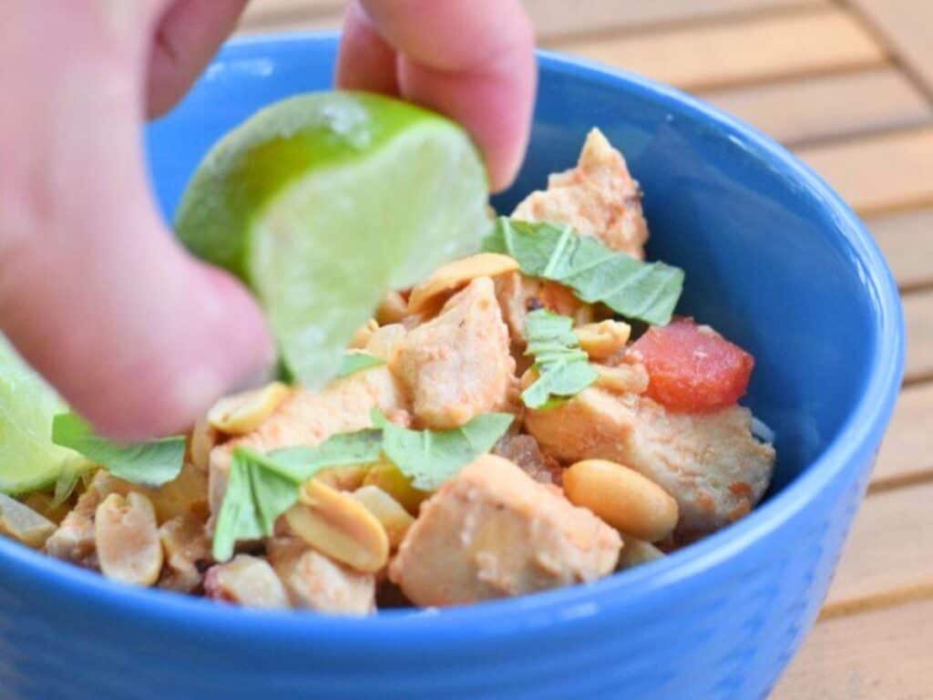 Image shows squeezing lime over yummy Thai chicken chili.