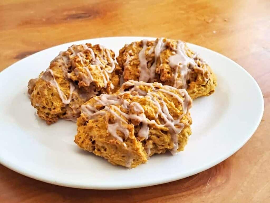 Image shows three delicious pumpkin scones on a white plate.