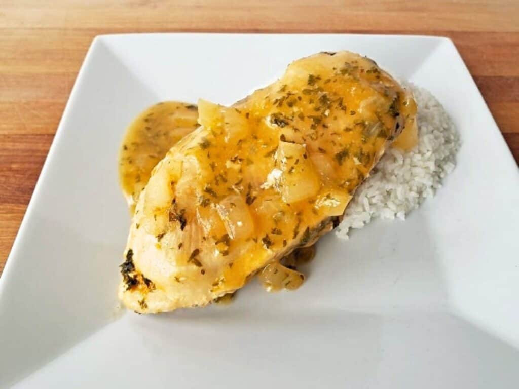 Image shows easy gluten-free lemon garlic chicken on a plate with rice.