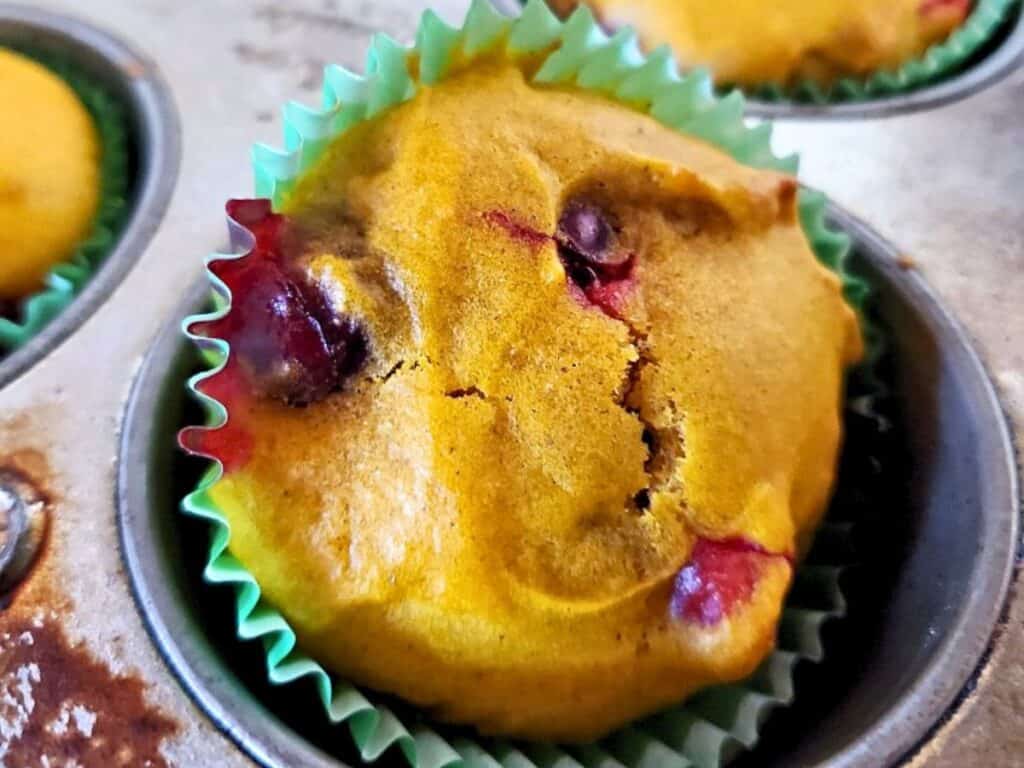 Image shows easy to make carrot cranberry muffin in a tin.