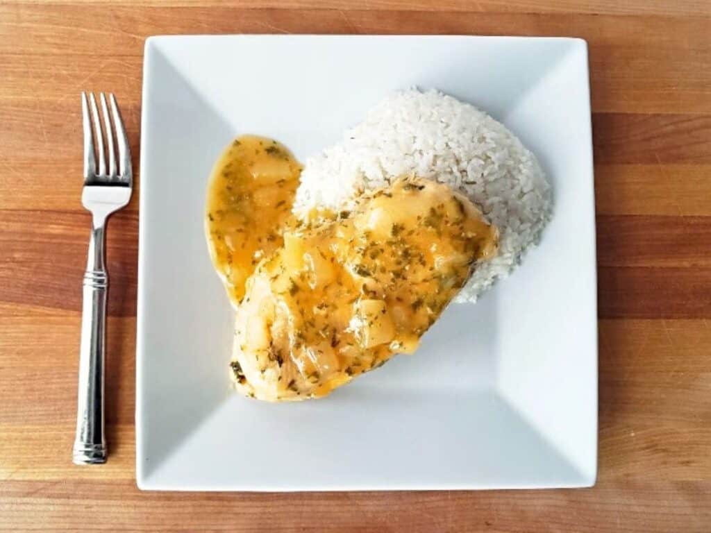 Image shows plated lemon garlic chicken recipe.