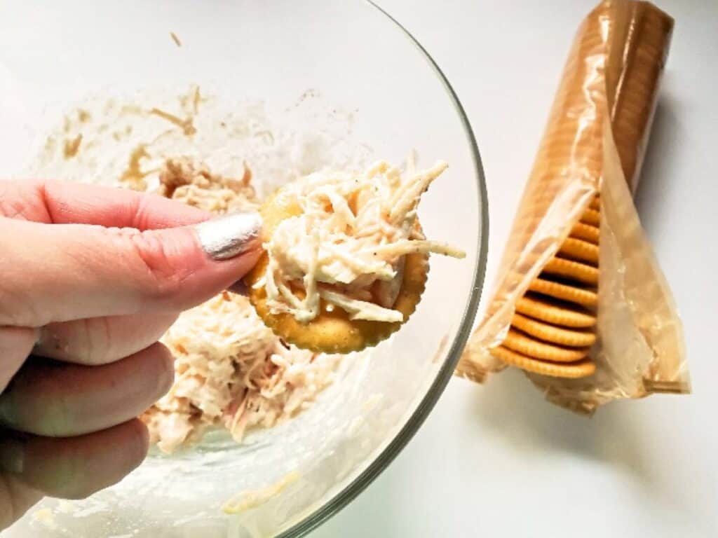 Image shows easy to make canned chicken salad on a cracker.