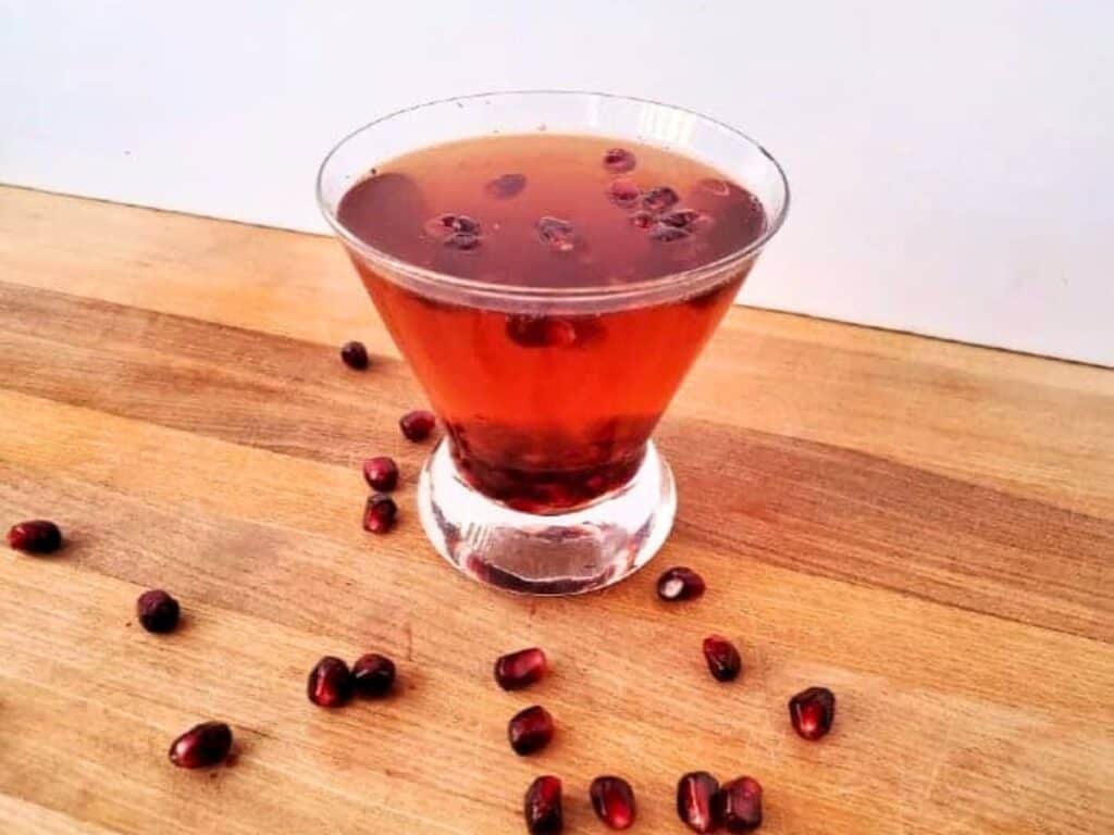Image shows yummy pomegranate fizz in a drinking glass.