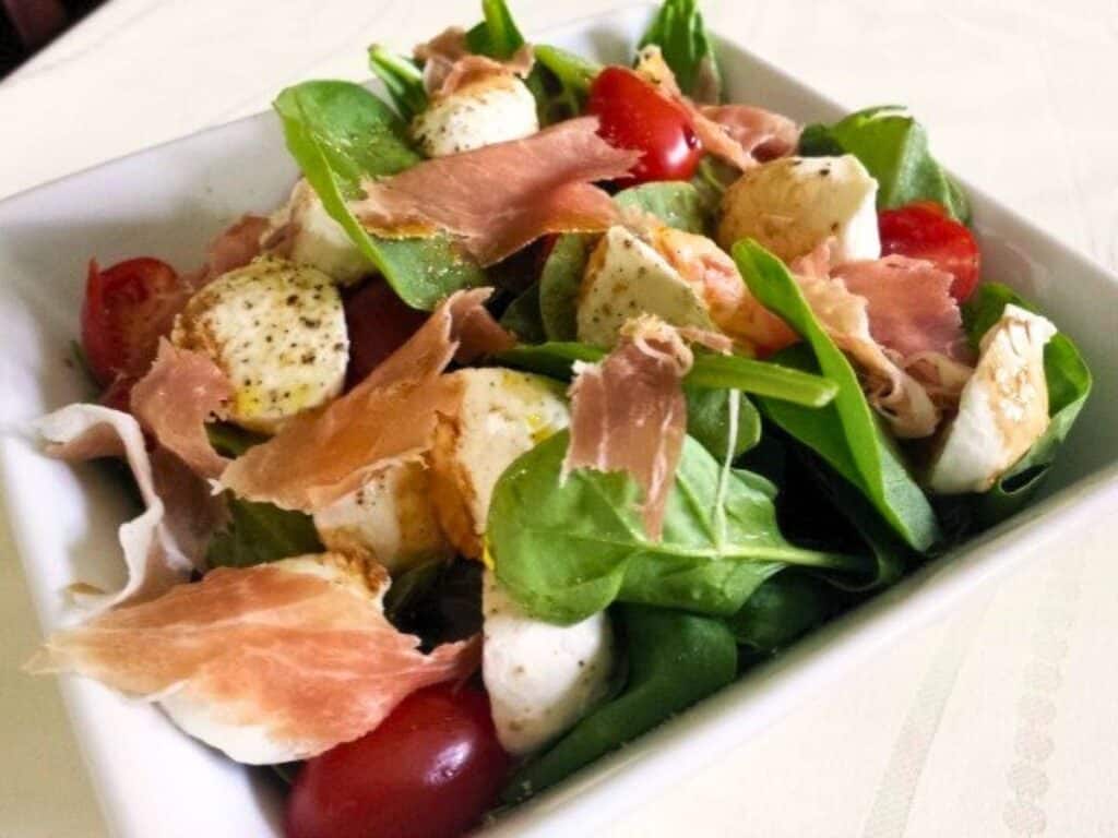Image shows yummy spinach caprese salad.