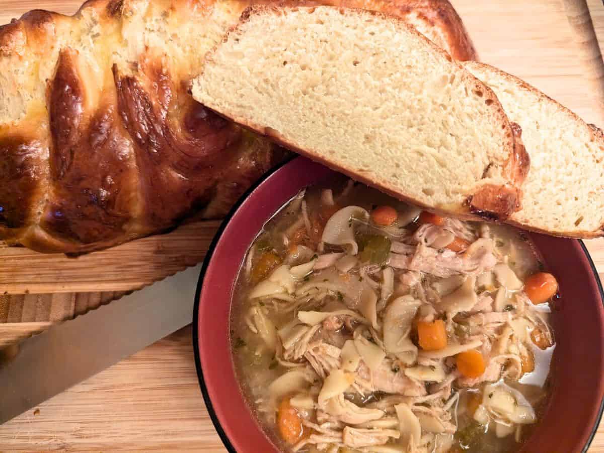 Image shows Instant Pot chicken noodle soup with challah.