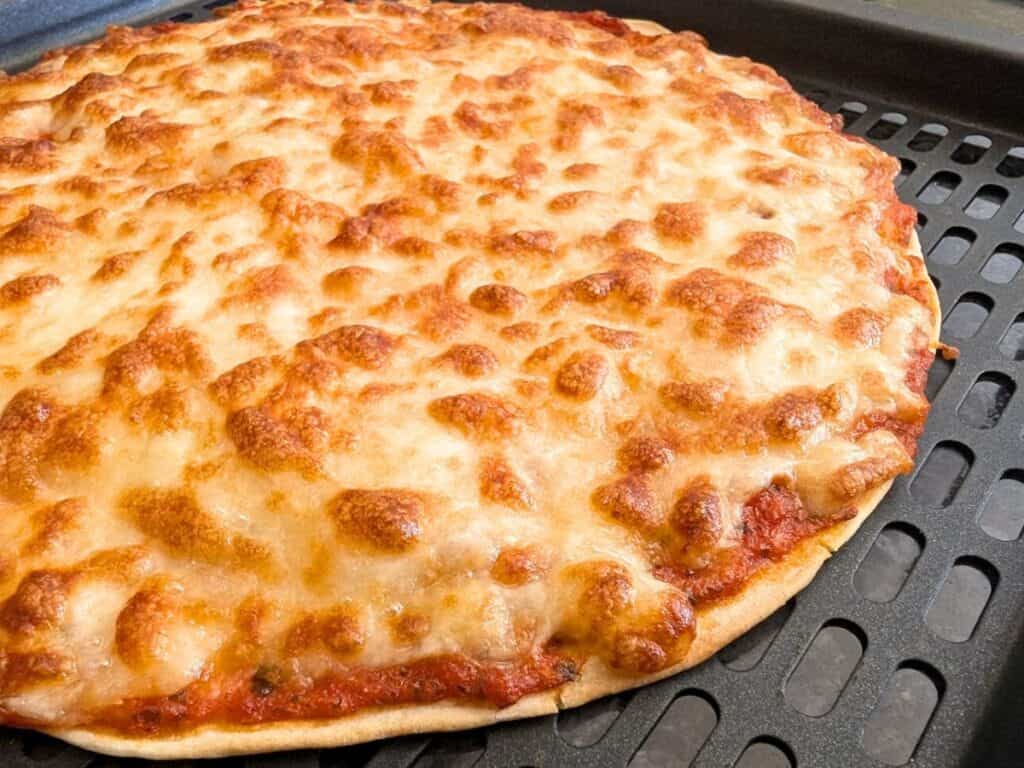 Image shows side view of the cooked air fryer tortilla pizza.