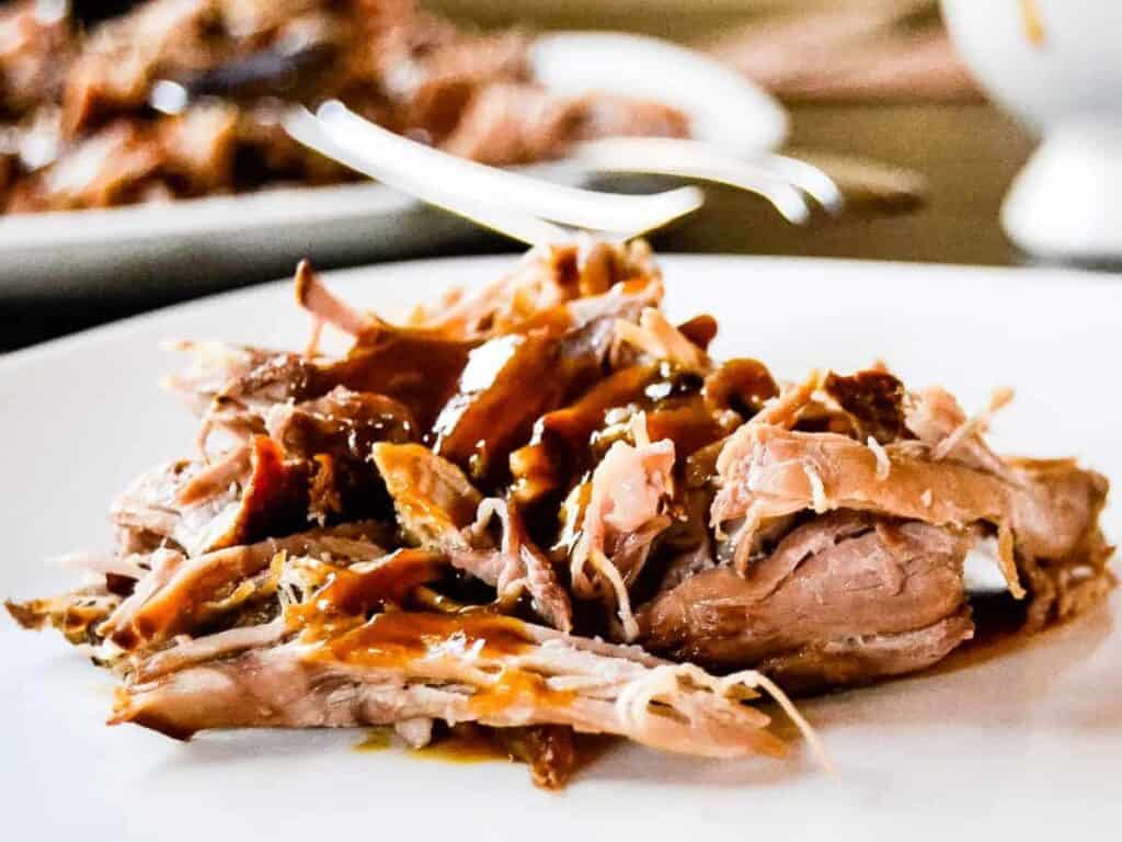 Image shows yummy slow cooker pork shoulder with mustard bbq sauce.