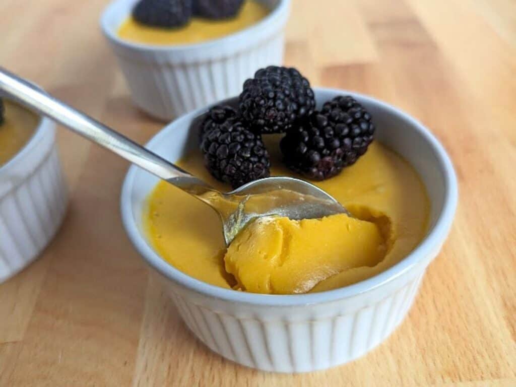 Image shows delicious mango mousse in a ramekin.