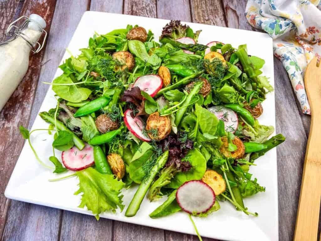 Image shows easy to make spring salad with asparagus, peas and potatoes.