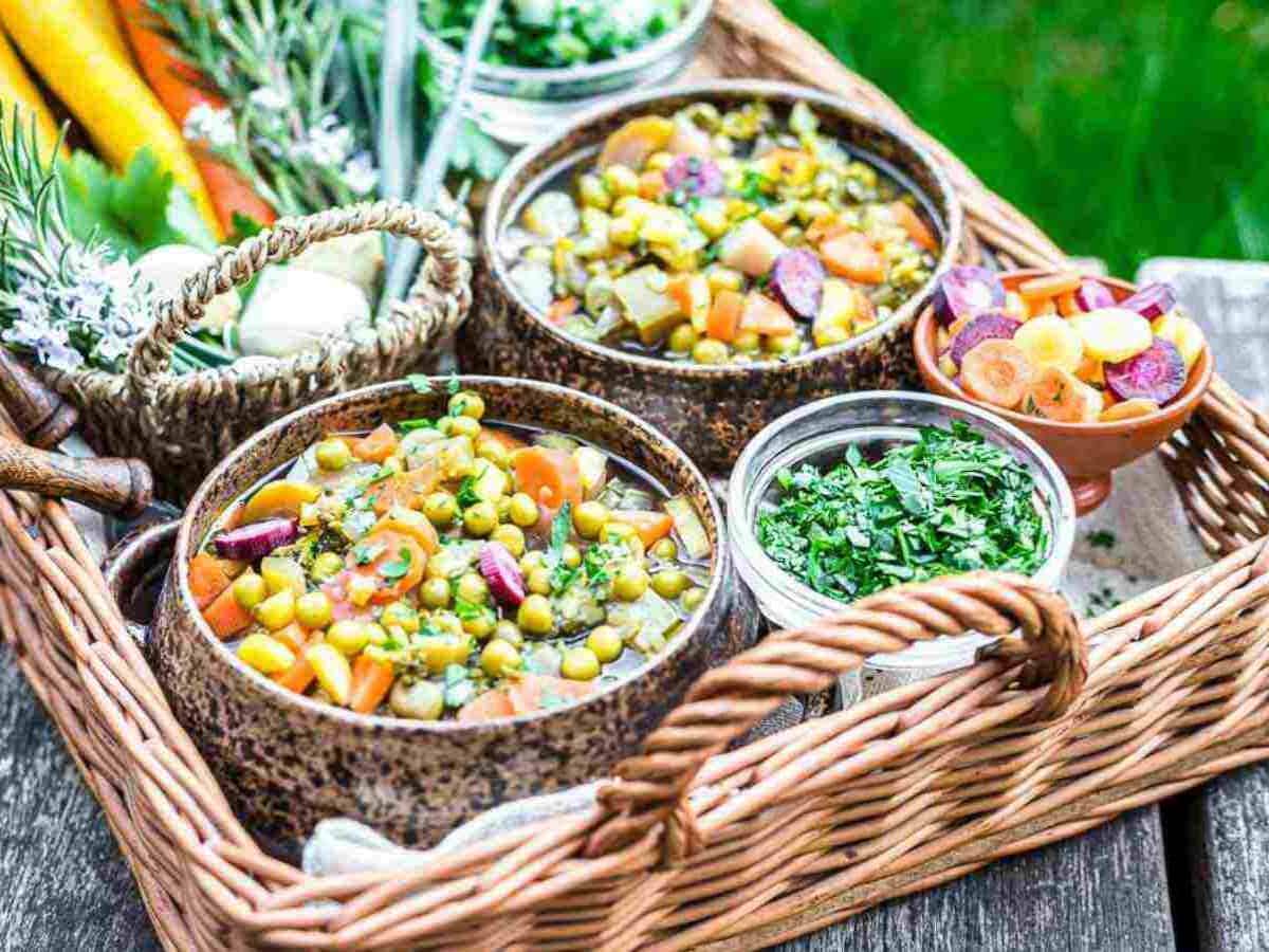 A wicker basket full of food on a wooden table.