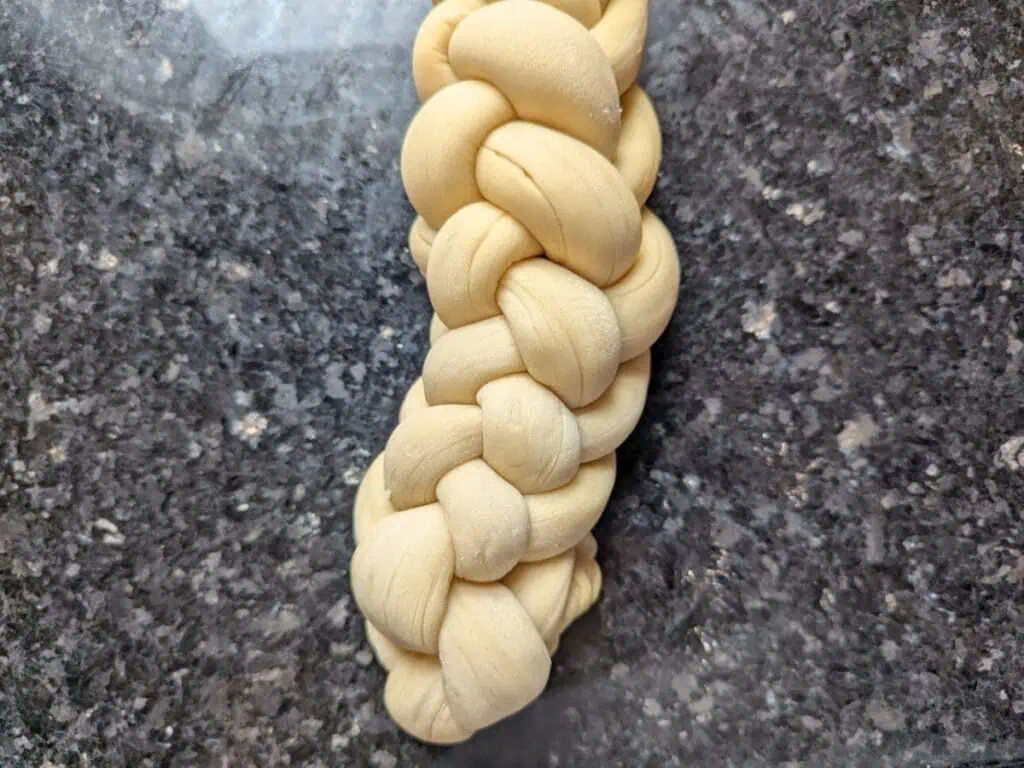 Image shows unbaked braided challah dough.
