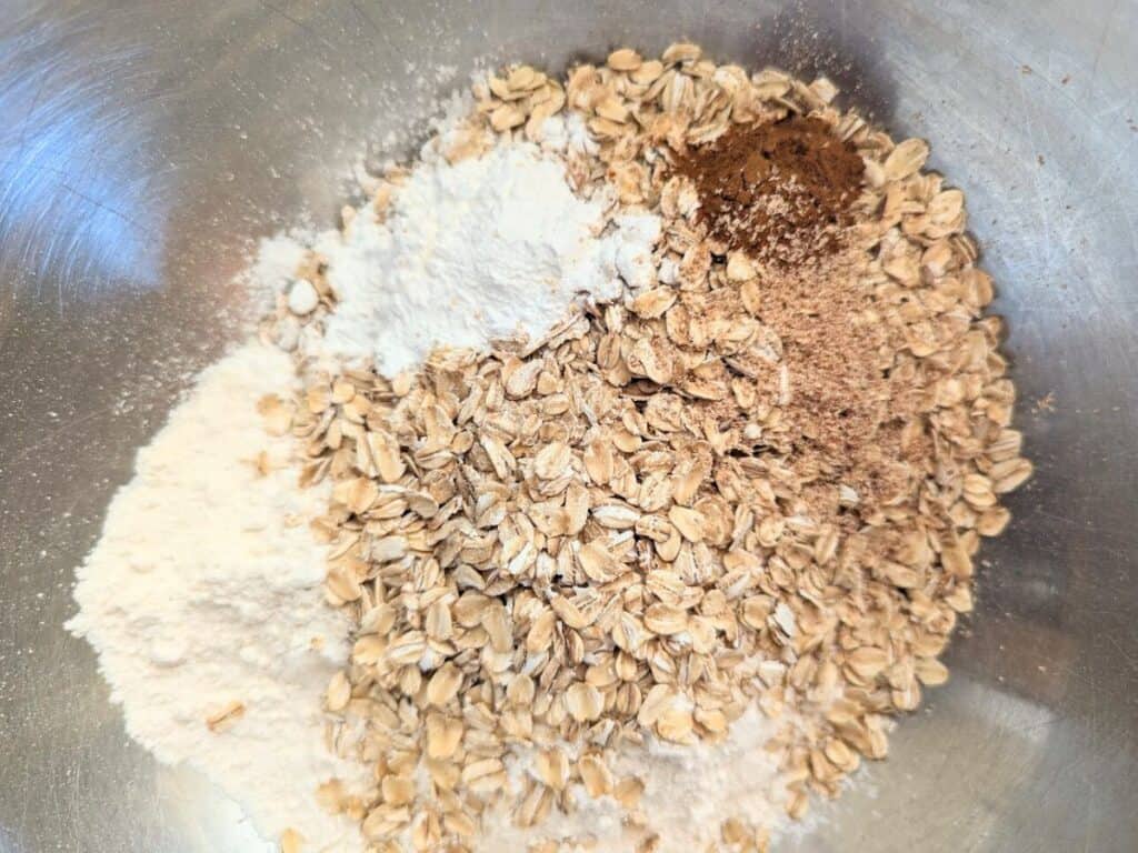 Image shows the Dry ingredients, including flour, oats, and spices, mixed in a bowl for apple scones.