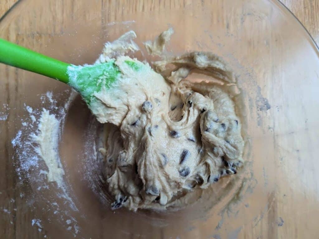 Image shows chocolate chips being added to the batter for an individual chocolate chip skillet cookie.