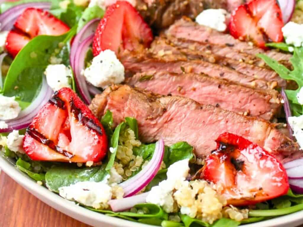 ;Image shows easy to make grilled steak and strawberry goat cheese salad with vinaigrette.