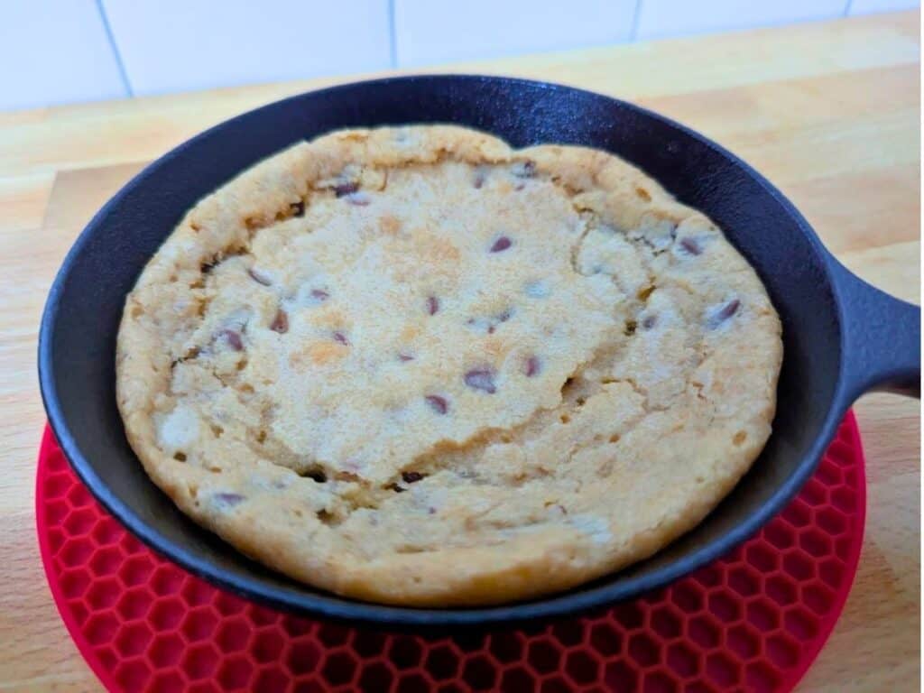 Image shows freshly baked individual chocolate chip skillet cookie.