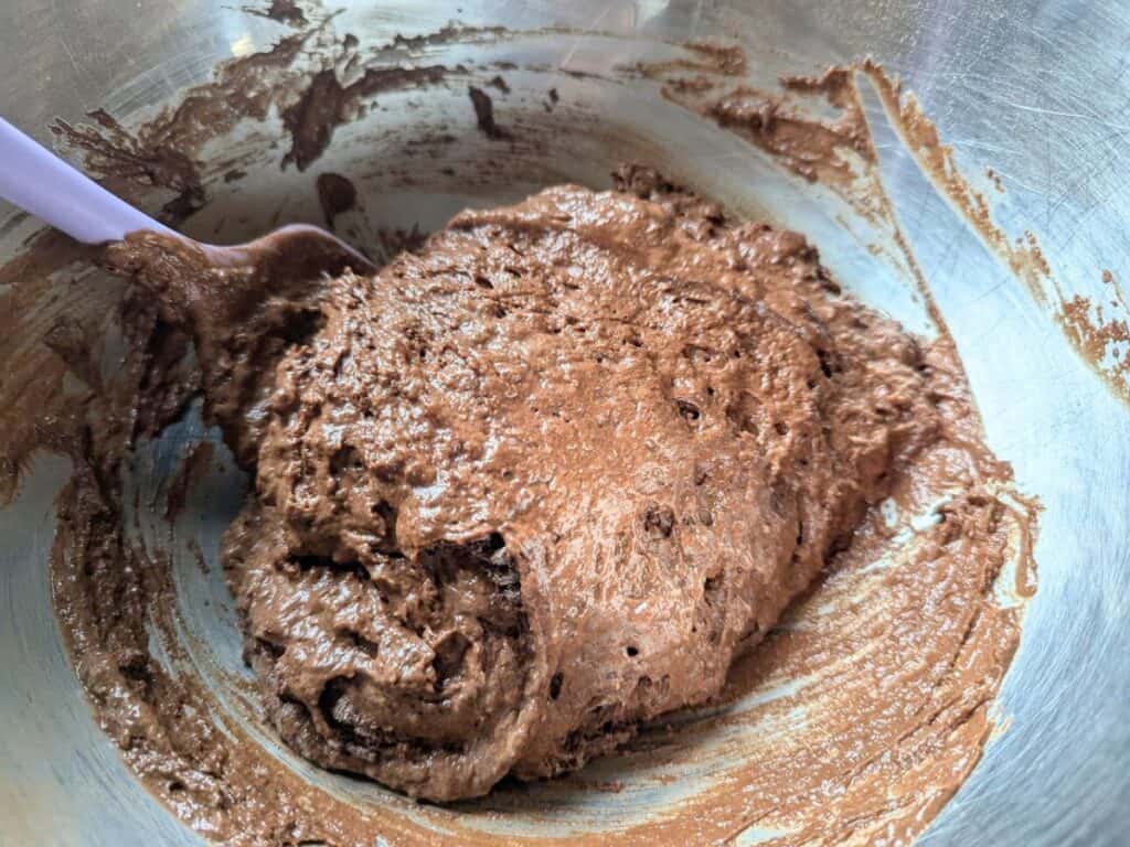Image shows a Thick chocolate batter for baked donuts in a mixing bowl.